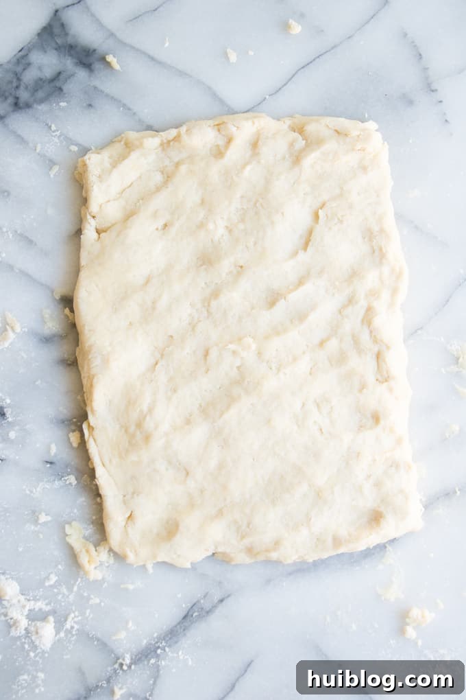 Fluffy Southern Biscuits from Scratch 8 A rectangular sheet of homemade biscuit dough, pressed to an even thickness, ready for cutting into individual biscuits, showing the potential for multiple layers.