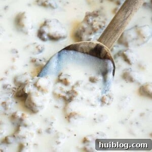 Spoon dipping into homemade sausage gravy.