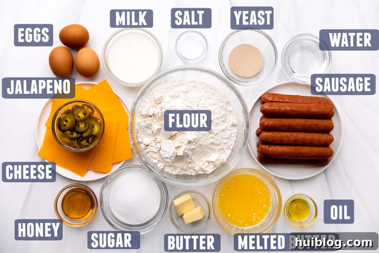 Texas Klobasnek Sausage Kolaches 3 Ingredients for making homemade Texas Sausage Kolaches laid out on a kitchen counter, including flour, yeast, butter, eggs, milk, sausages, cheese, and jalapeños.