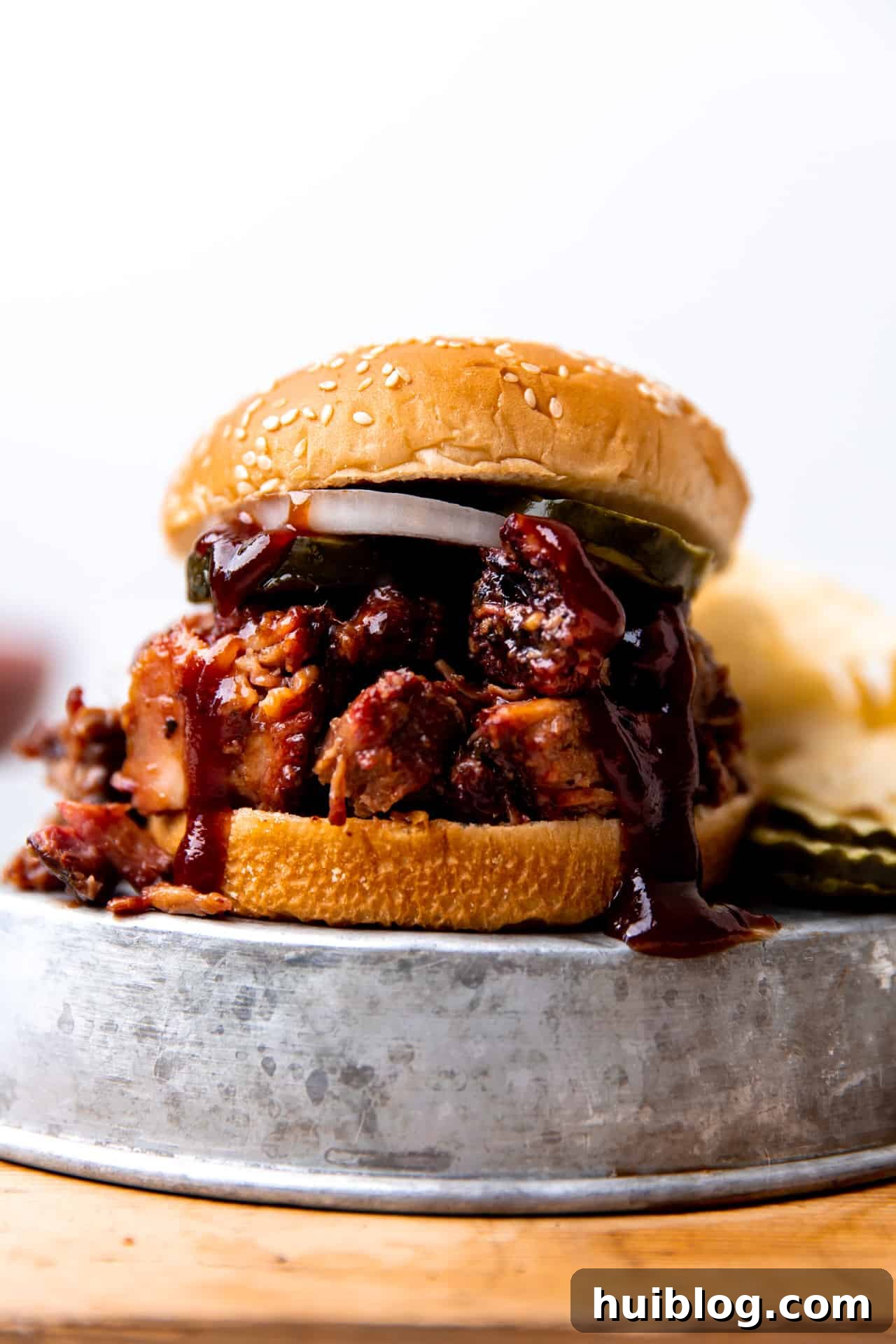 Pulled Pork BBQ Sandwiches 7 An inviting close-up view of a perfectly assembled chopped brisket sandwich, highlighting the tender meat, crisp pickles, and soft bun.