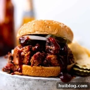 Smoked BBQ Brisket sandwich made with sauce, pickles and sliced onion. Served with chips