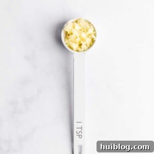 Measuring spoon with minced garlic.