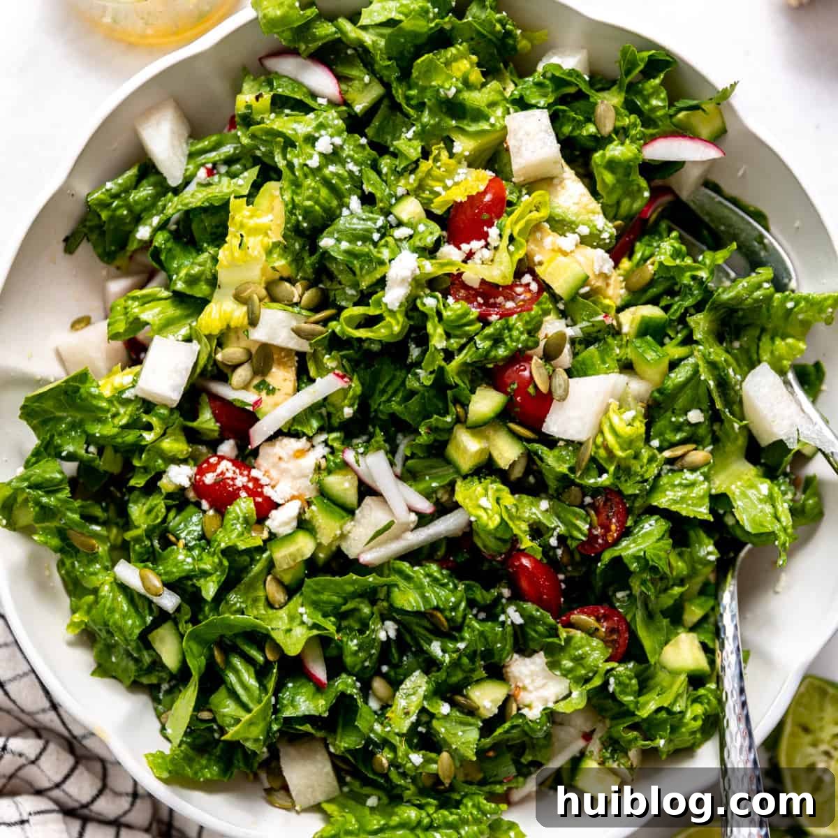 Fiesta Salad Bowl 7 Mexican salad tossed with dressing, ready to serve in a large white bowl.