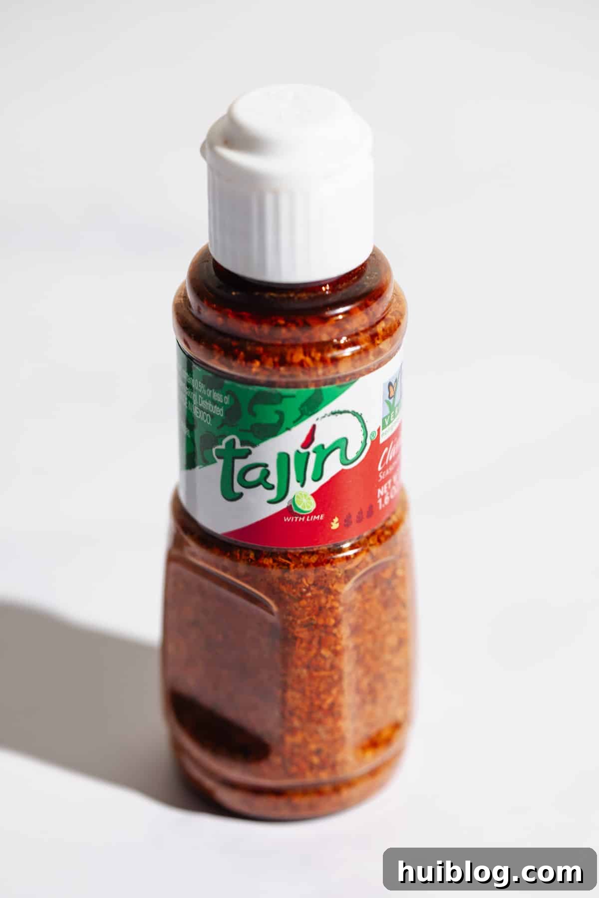 Tajin Understanding Its Flavor and Usage 2 A bottle of Tajín seasoning, un-opened, showcasing its vibrant red color and iconic label.