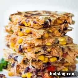 A stack of golden-brown Texas Cowboy Quesadillas, filled with savory ingredients and melted cheese.