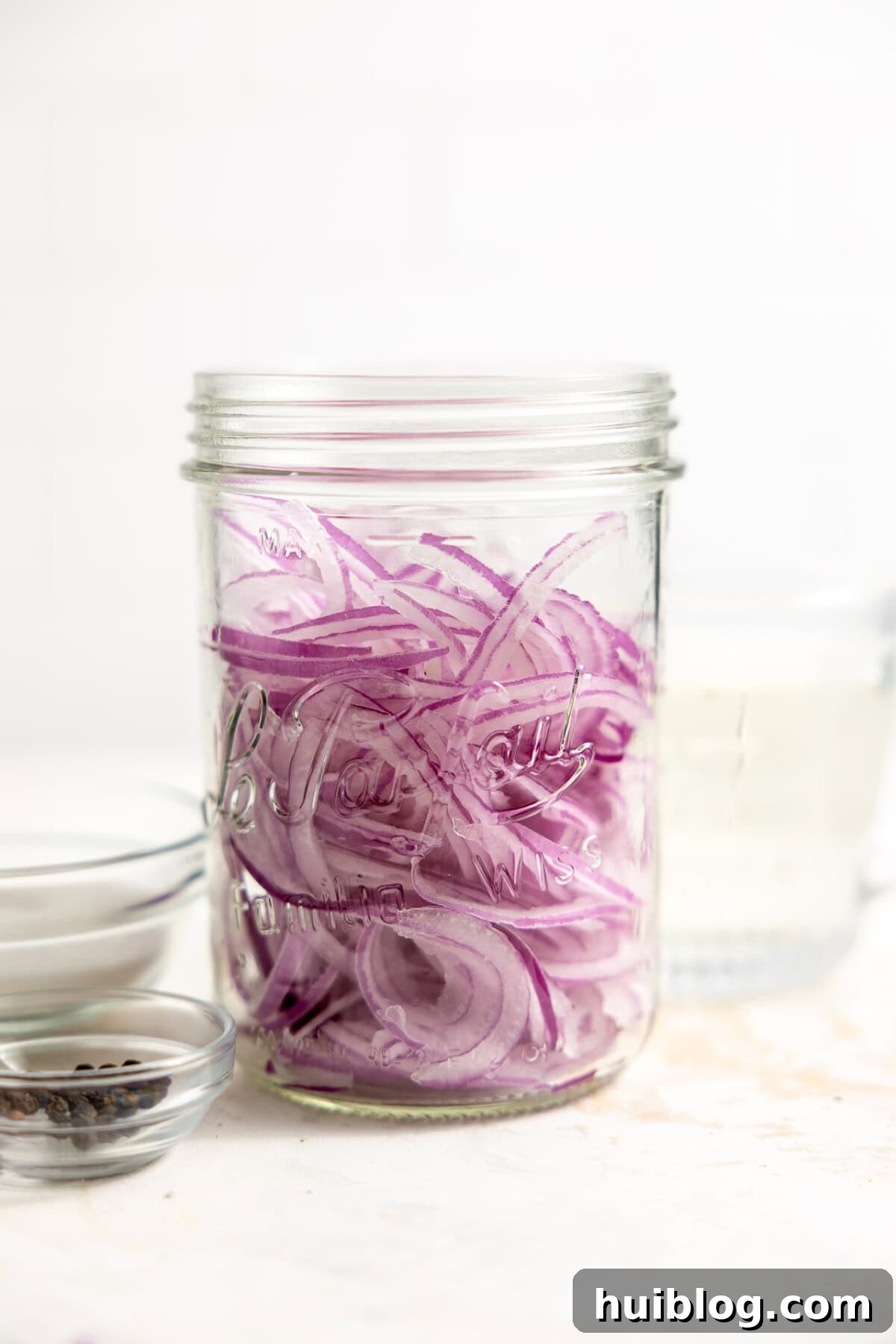 My Secret Weapon Pickled Red Onions 7 Thinly sliced red onions in a jar.