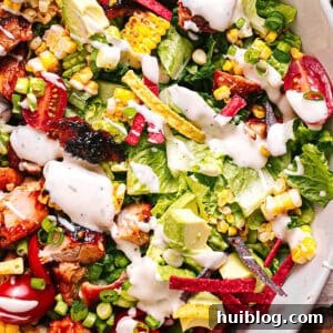 Close-up of a delicious BBQ Chicken Salad with ranch dressing, showcasing the rich colors and textures of tender chicken, fresh greens, and vibrant toppings.