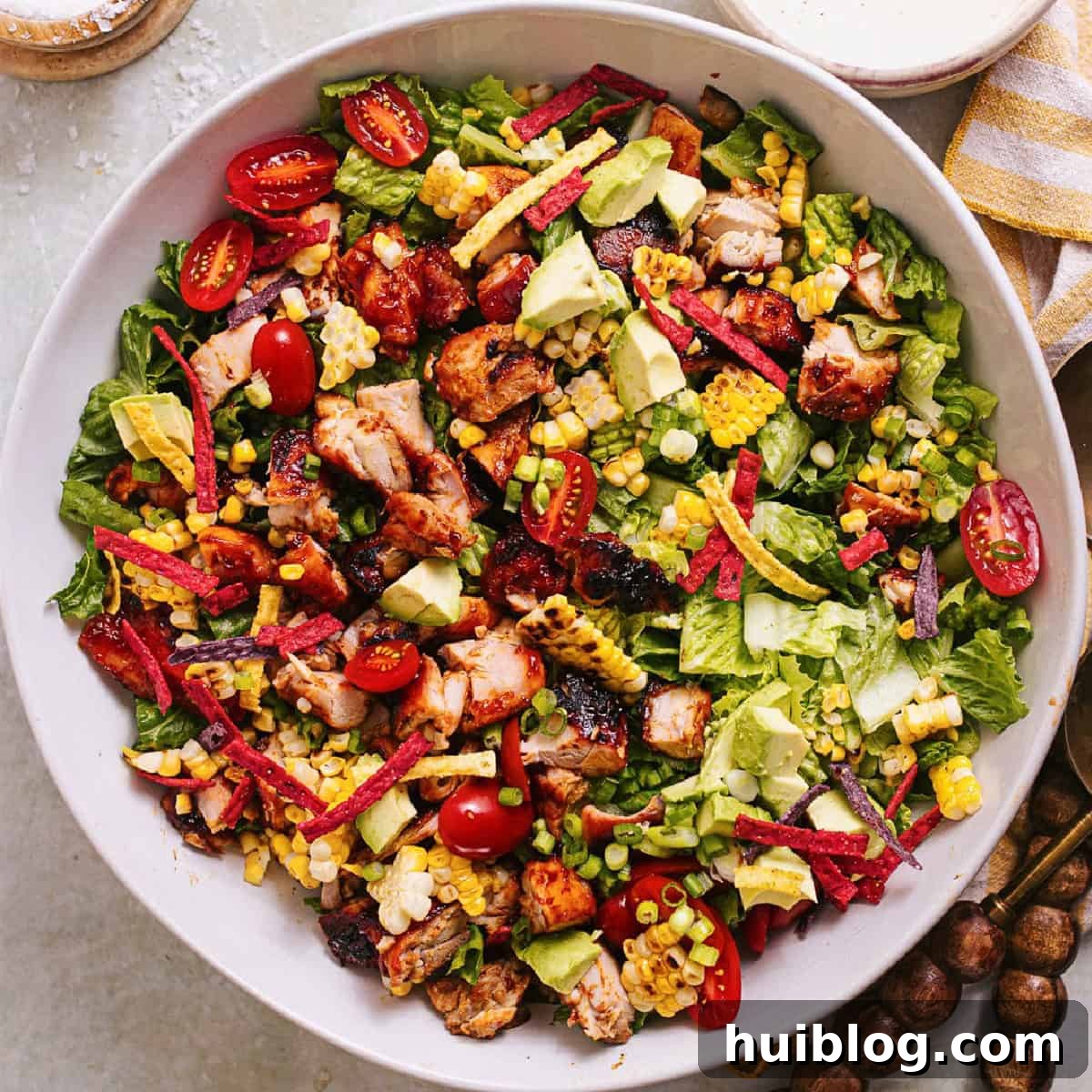 BBQ Chicken Salad Delights 9 A beautifully assembled and dressed BBQ Chicken Salad in a rustic bowl, showcasing layers of tender chicken, fresh vegetables, and crispy toppings, ready to be enjoyed.