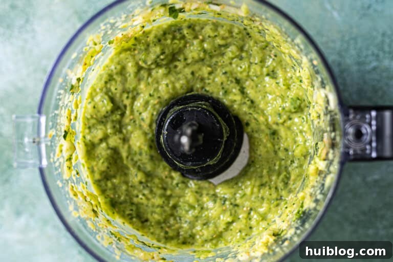 Smooth, blended avocado salsa in a food processor.
