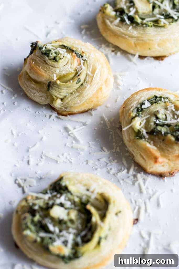 Flaky Spinach Artichoke Swirls 4 A tray of golden, crispy Puff Pastry Spinach and Artichoke Pinwheels, freshly baked and ready to eat.