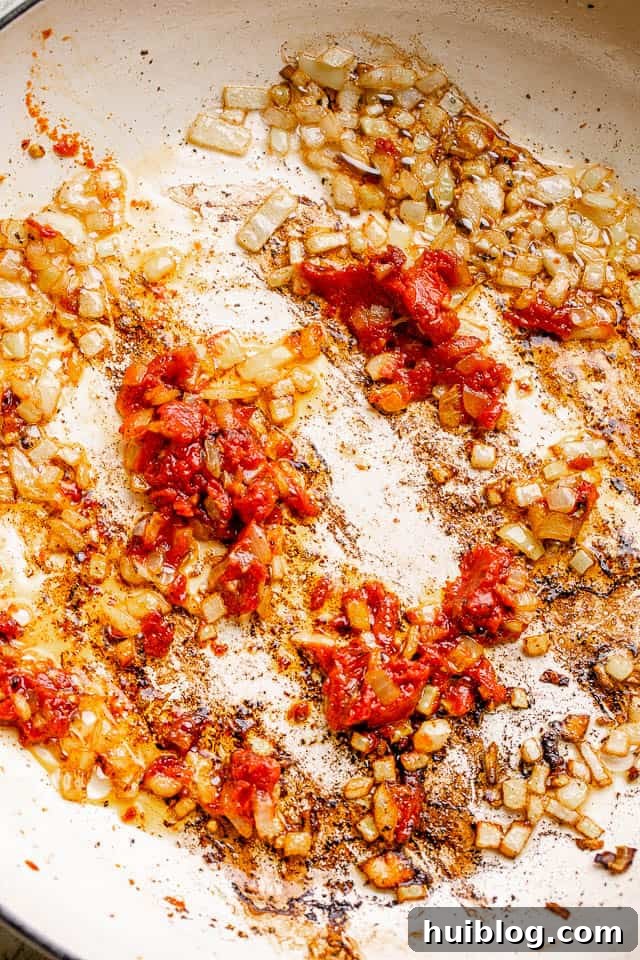 Sweet and Smoky Maple Bacon Baked Beans 4 Frying diced onions in a white skillet with bacon grease.