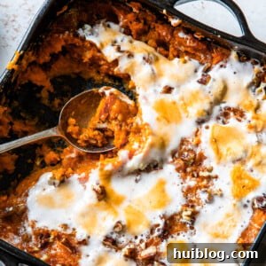 Sweet potato casserole with a spoon scooping out a portion.