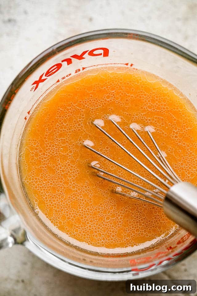 Whisking chicken stir fry sauce ingredients in a bowl