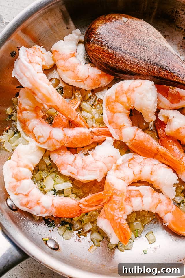 Velvety Shrimp Alfredo Pasta 2 Shrimp sauteing in a pan with garlic.