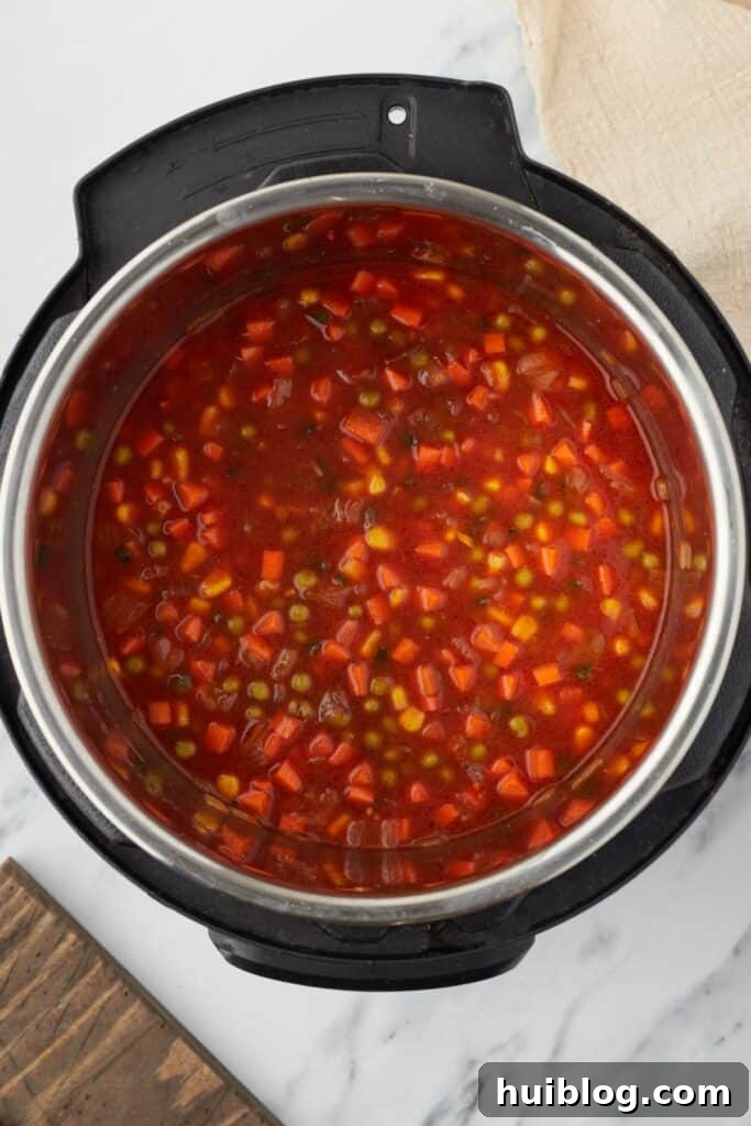 Overhead shot of an Instant Pot, with all ingredients for Mexican rice combined and ready for pressure cooking.