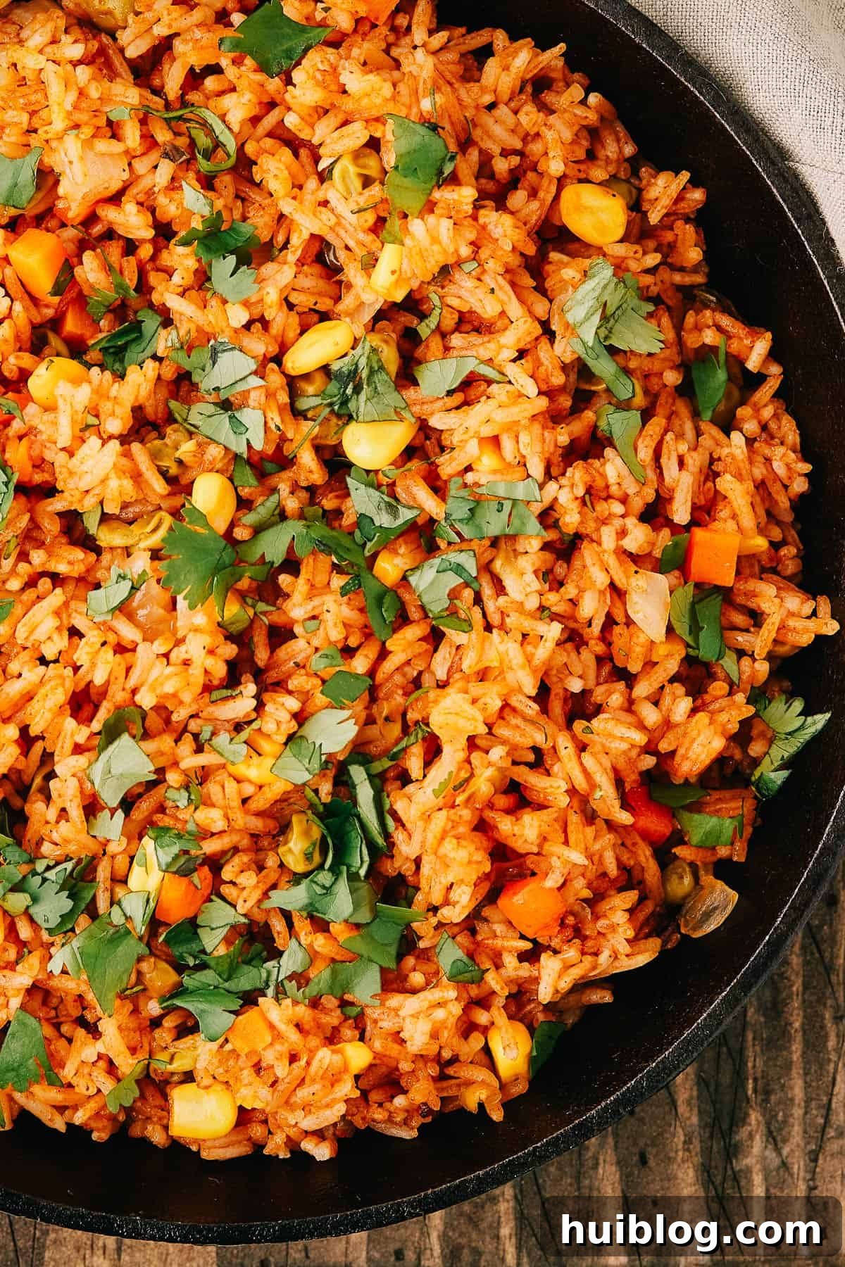 Close-up shot of a pan of seasoned Instant Pot Mexican Rice and vegetables, beautifully garnished with fresh cilantro.