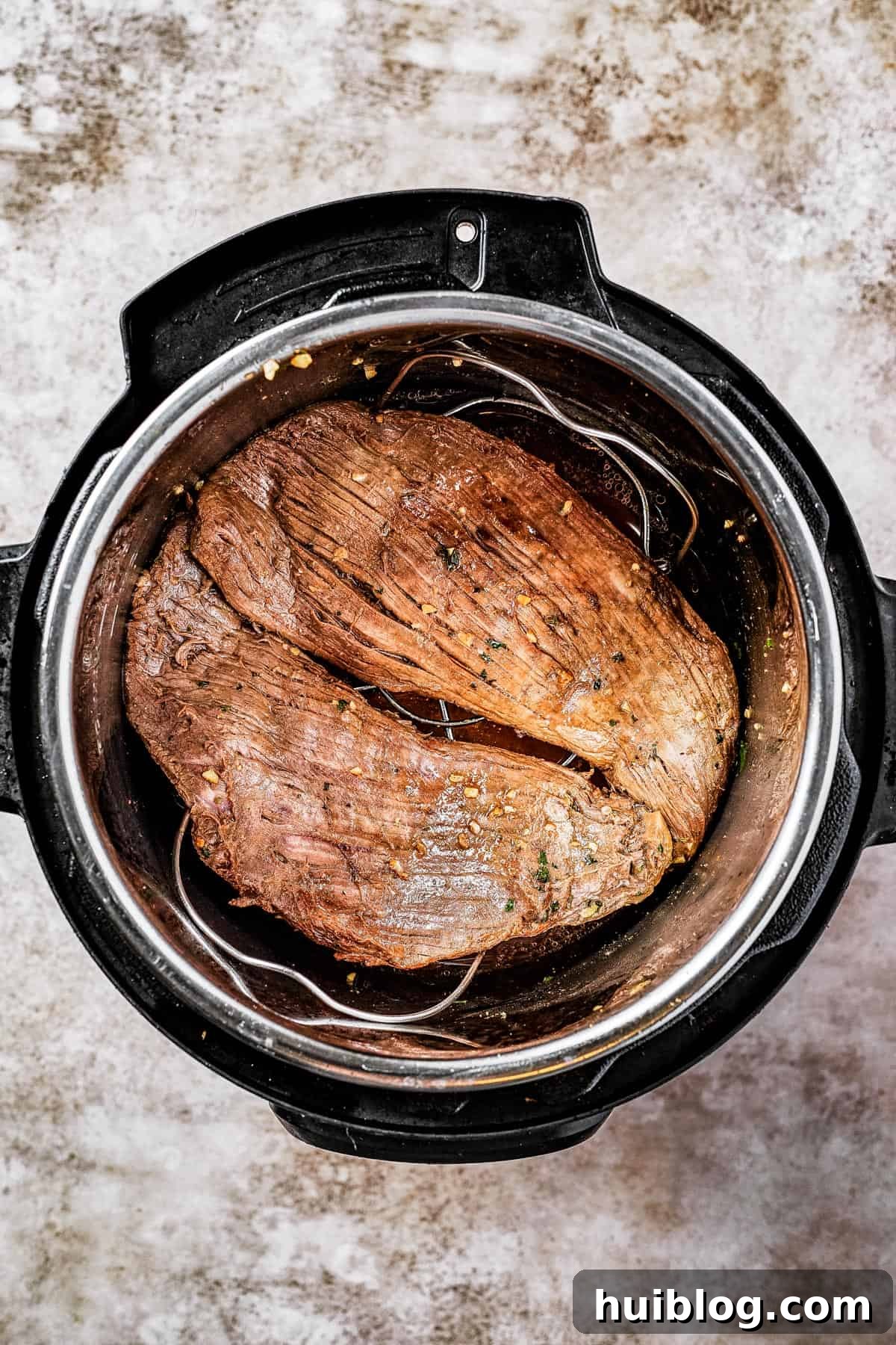 Flank steak browning in an Instant Pot, showing the searing process.