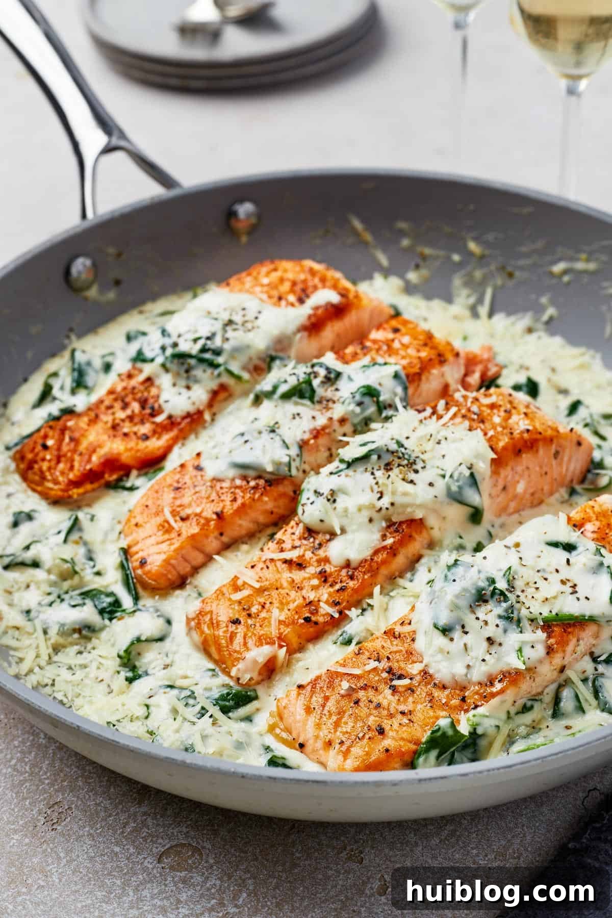 Close-up shot of pan-fried salmon in Florentine sauce.
