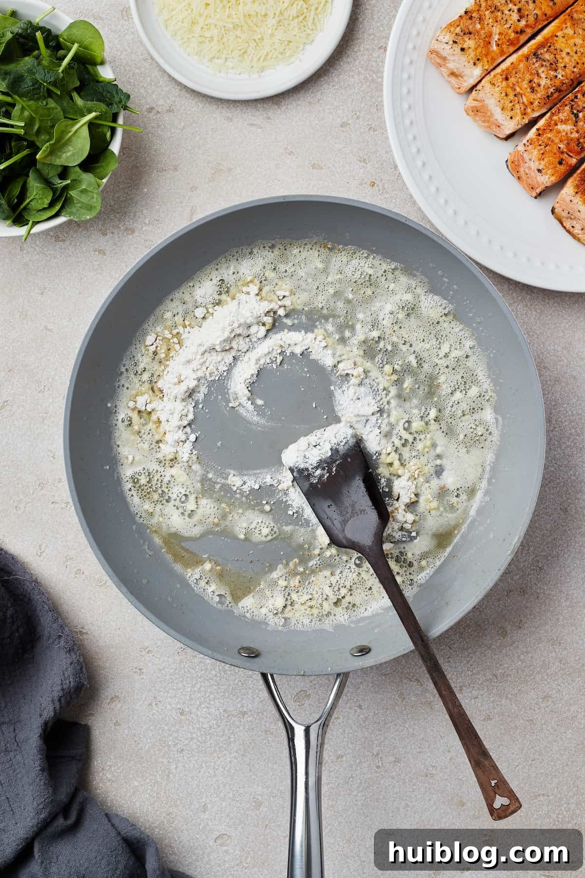 Pan-Seared Salmon with Creamy Spinach 6 A skillet with melted butter, garlic, and flour cooking in it.