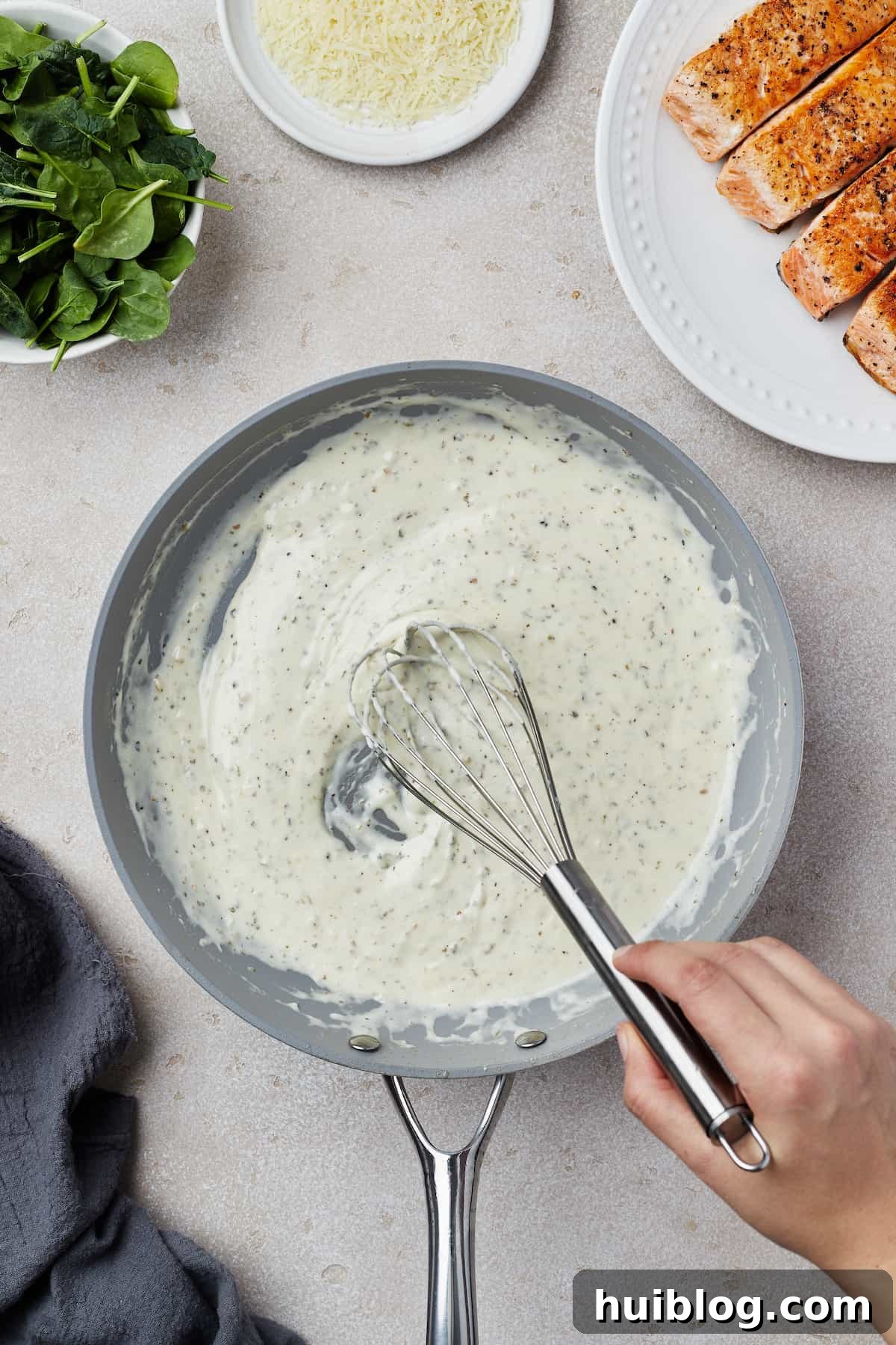 Pan-Seared Salmon with Creamy Spinach 7 Creamy sauce being whisked in a skillet.