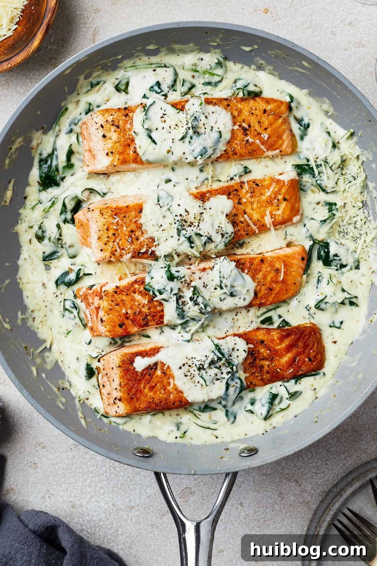 Pan-Seared Salmon with Creamy Spinach 9 Salmon fillets in creamy spinach sauce in a gray nonstick skillet.