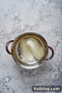 Korean Beef and Glass Noodle Japchae 2 Glass noodles rehydrating in a stainless steel pot of hot water, softening for the Japchae recipe.
