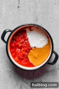 Rich Peanut Glazed Chicken 4 Crushed tomatoes, peanut butter, and coconut milk in a large pot.