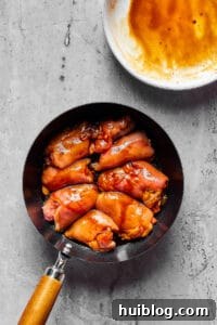Creamy Peanut Butter Chicken 4 Chicken thighs searing to a golden brown in a hot skillet, developing a flavorful crust before being added to the sauce.