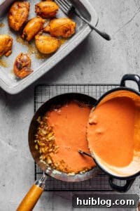 Creamy Peanut Butter Chicken 5 Finely chopped onions sautéing in a skillet, with a bowl of cooked chicken and the rich peanut sauce ready to be added, showcasing the cooking process.