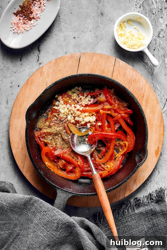 Bell peppers, seasonings, and garlic in a skillet.