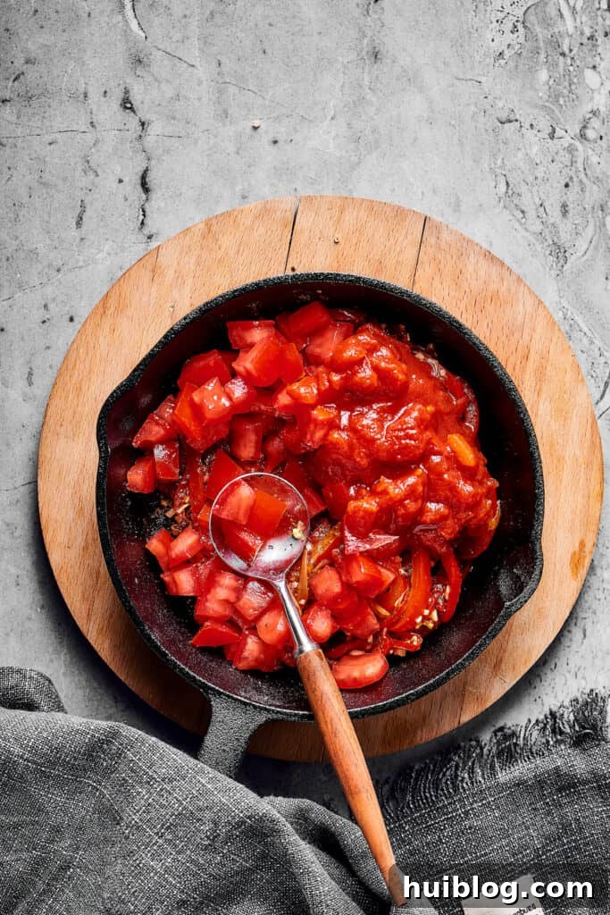 Tomatoes, bell pepper, and onion in a skillet.
