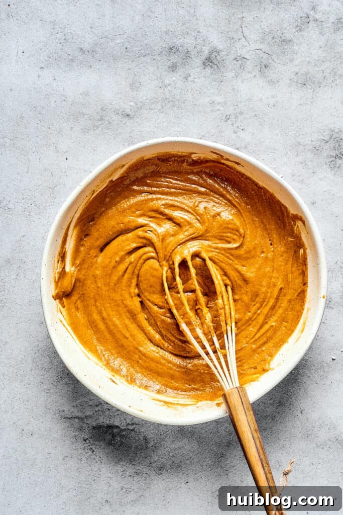 Swirled Pumpkin Cream Cheese Muffins 4 Pumpkin muffin batter in a mixing bowl, showcasing its rich orange color and smooth consistency.