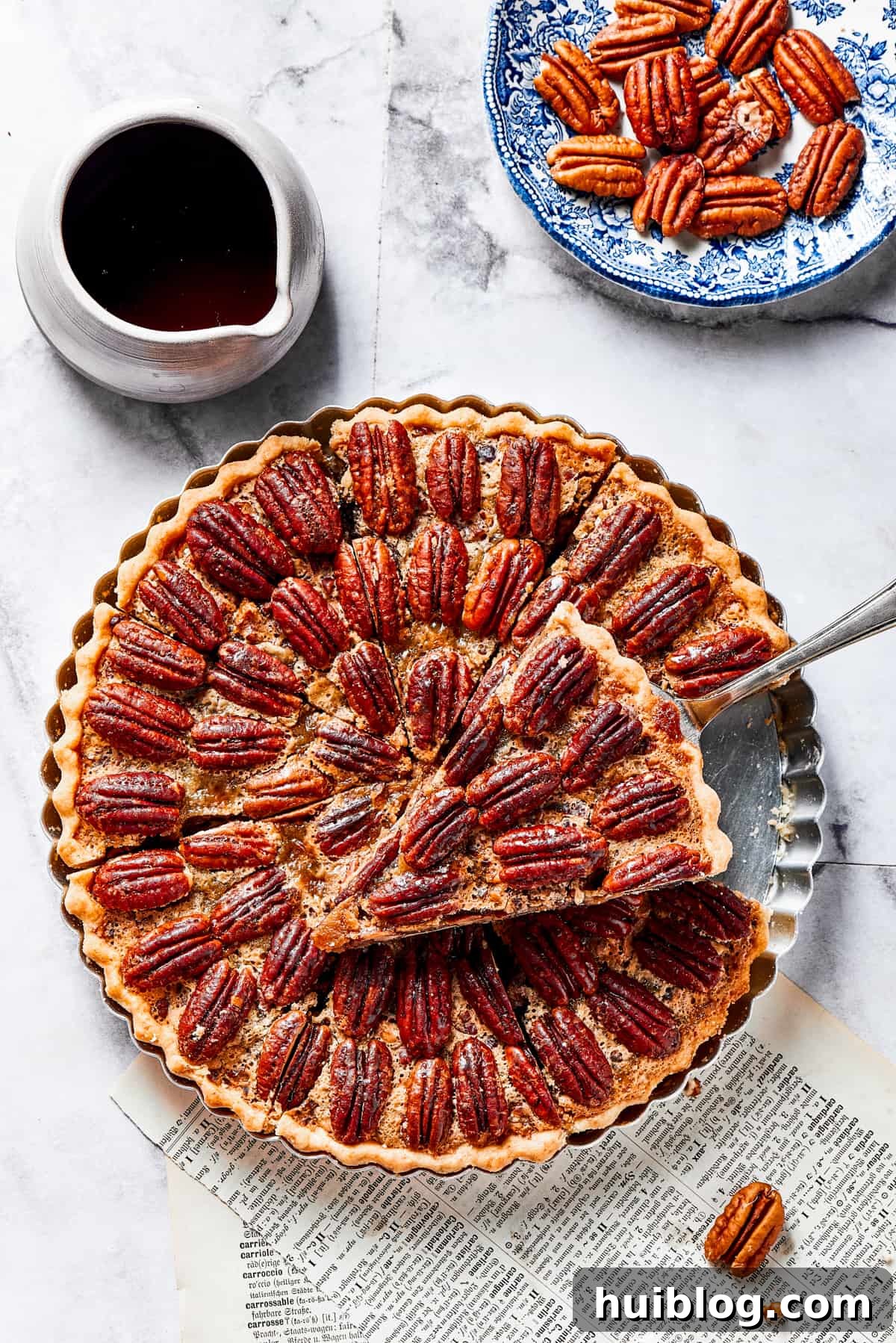 A slice of pie on a pie server, held just above the rest of the pie.