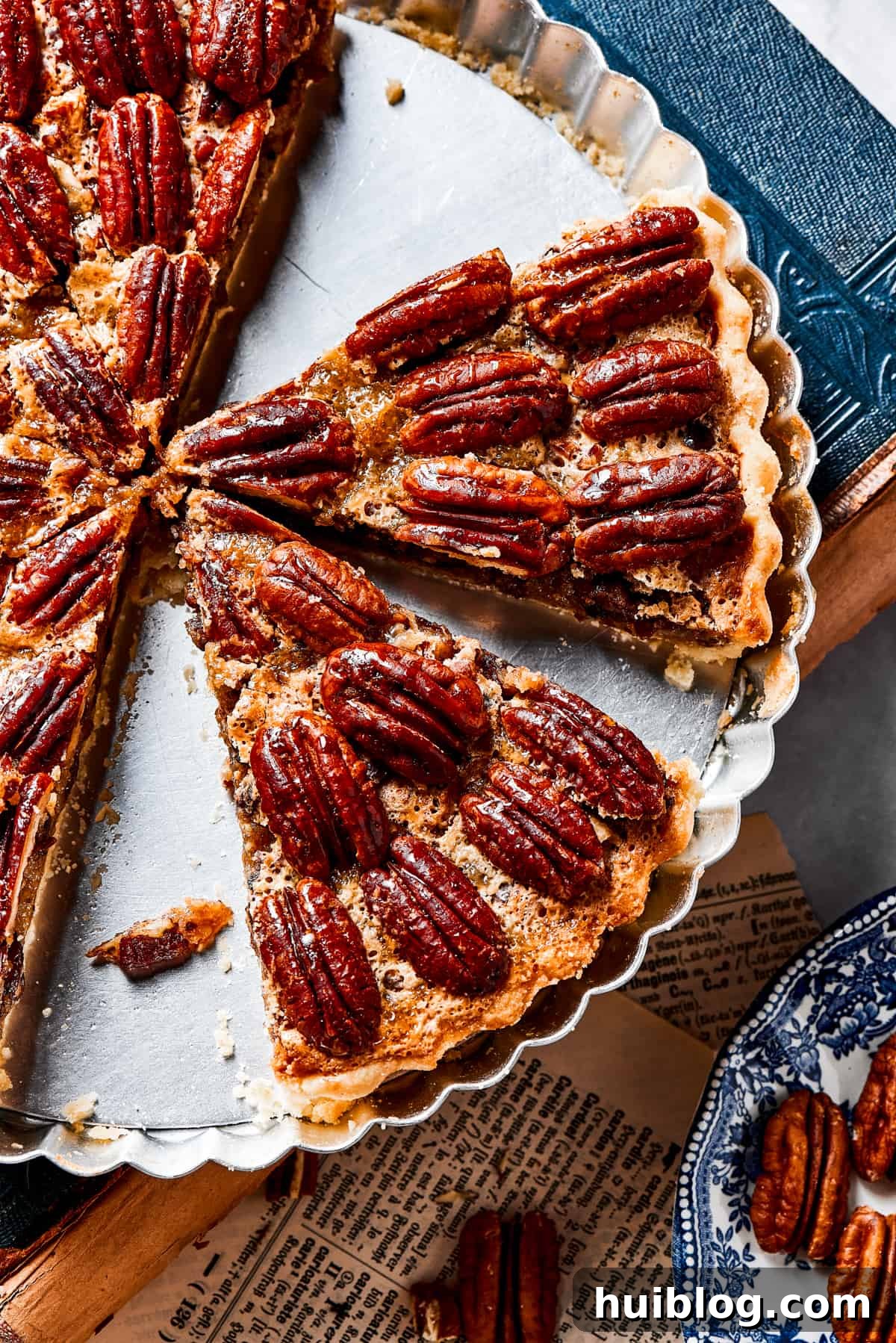 A pie dish with several slices of pecan pie left in it.