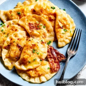Homemade Pierogi Recipe - Classic Cheese-and-Potato Dumplings! Homemade potato-filled dumplings on a blue plate with a fork.