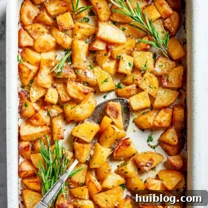 A large baking dish full of baked, seasoned potato pieces.