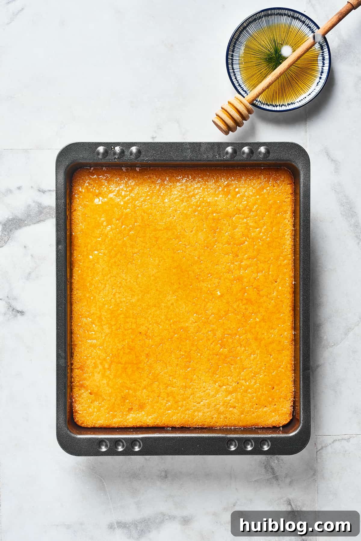 A perfectly baked loaf of golden cornbread sitting in a rectangular baking dish, ready to be sliced and served.