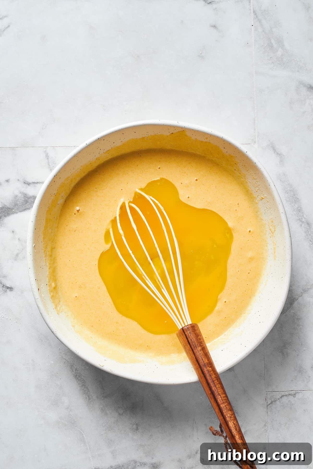 A whisk creates a well in the center of the dry ingredients, preparing for the addition of wet components.