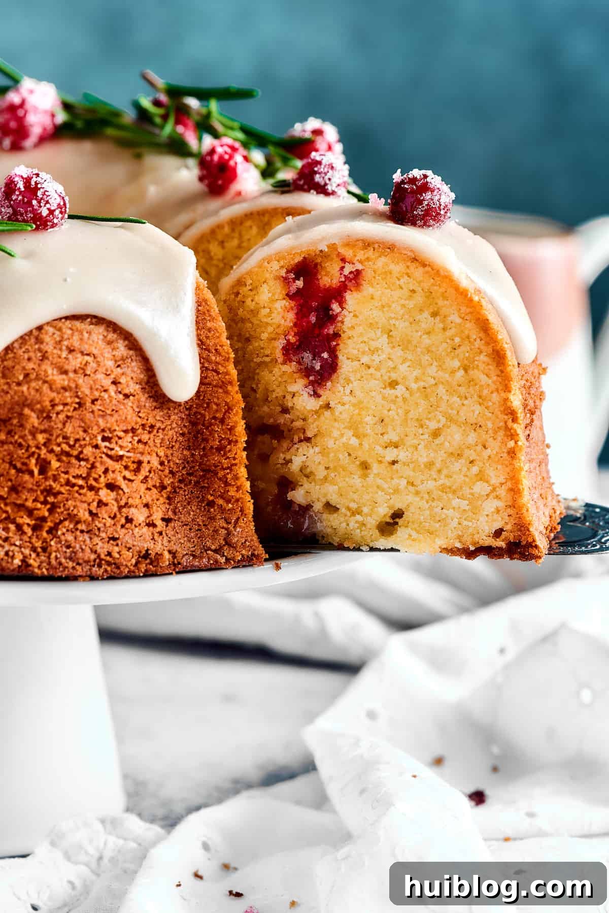 A slice of Christmas Cranberry Pound Cake being lifted from the cake with a silver cake server.