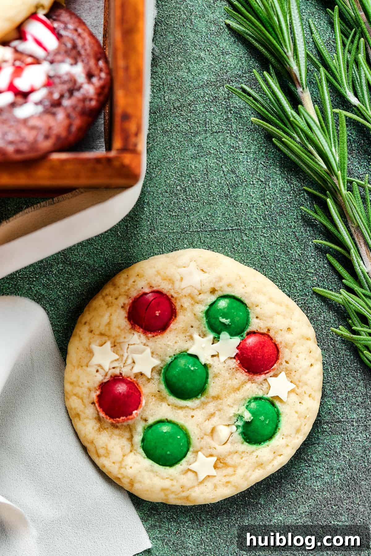 A beautifully decorated Christmas sugar cookie featuring elegant white chocolate stars and festive red and green M&Ms, symbolizing holiday cheer and sweet indulgence.