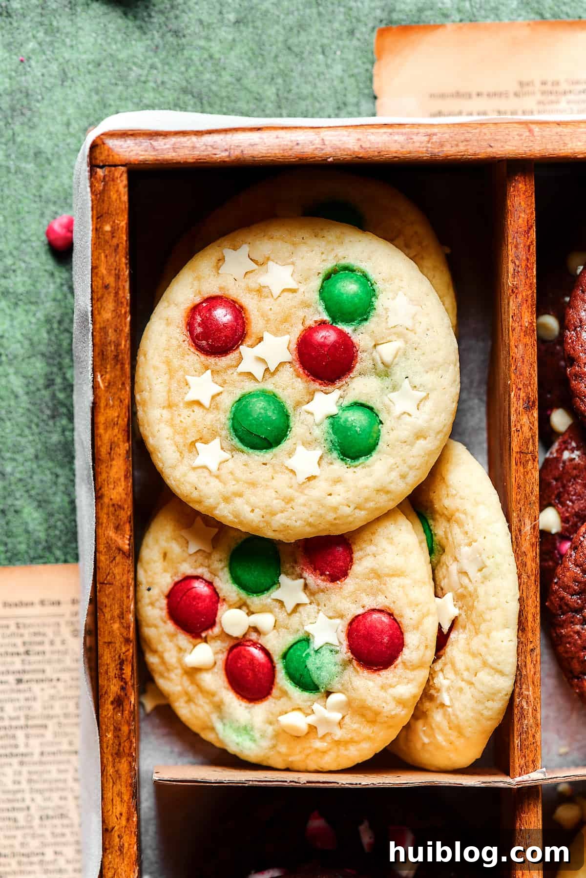 A festive sugar cookie with white chocolate stars and colorful red and green M&Ms arranged on top, ready to celebrate the holidays.