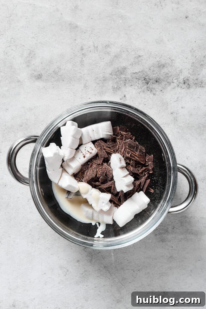 No-Bake Chocolate Crispy Treats 8 Melted chocolate and marshmallows in a bowl over a double boiler, showing the smooth, combined texture of the topping.