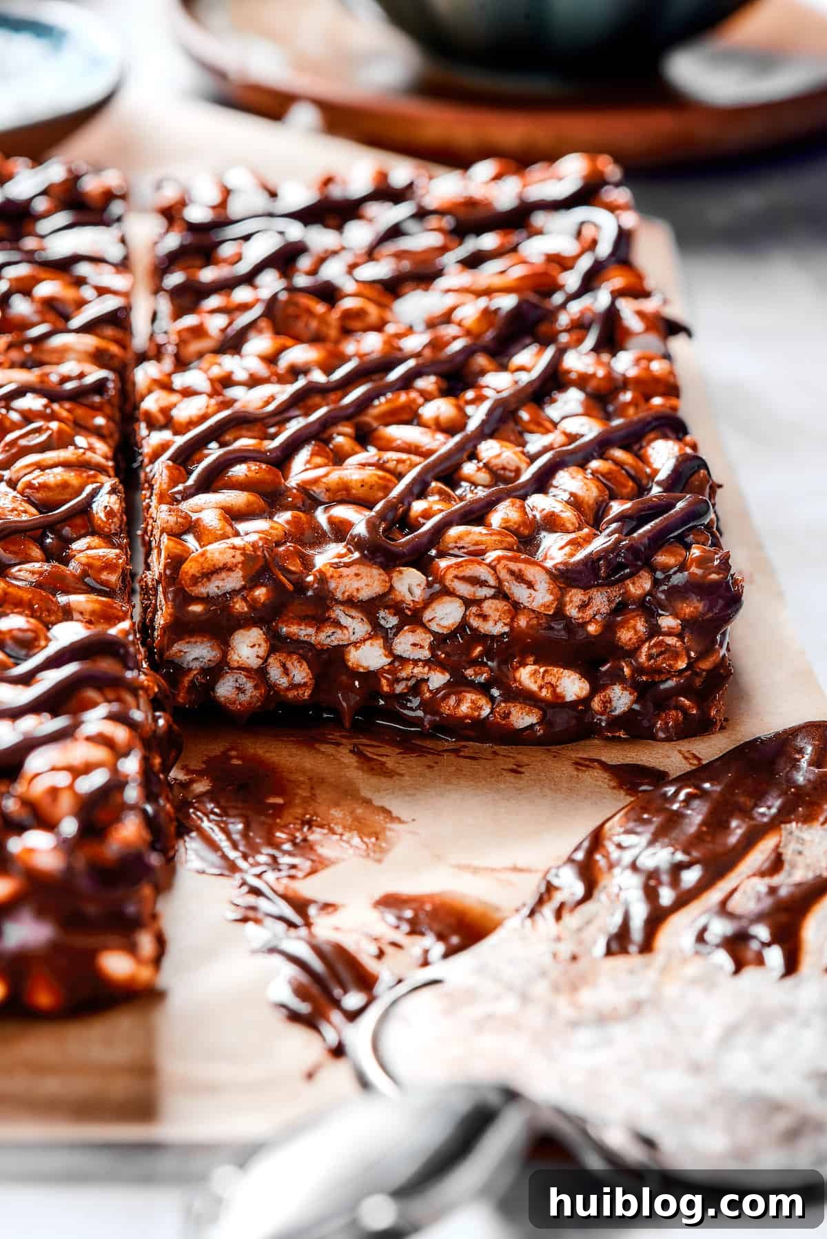 A delicious stack of chocolate rice krispie treats, highlighting the rich chocolate and marshmallow layers. Close-up of chocolate cereal bar squares with a generous chocolate and marshmallow topping, ready for enjoyment.