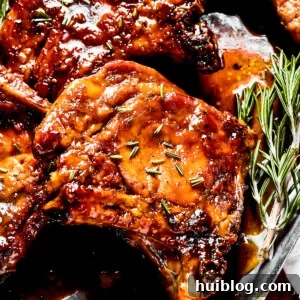 Sticky Sweet Pork Chops 2 Pork chops glazed in brown sugar sauce, garnished with herbs.