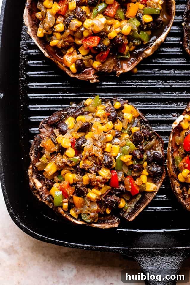 Portobello mushrooms stuffed with black beans and corn, grilling on an outdoor rack until perfectly tender.