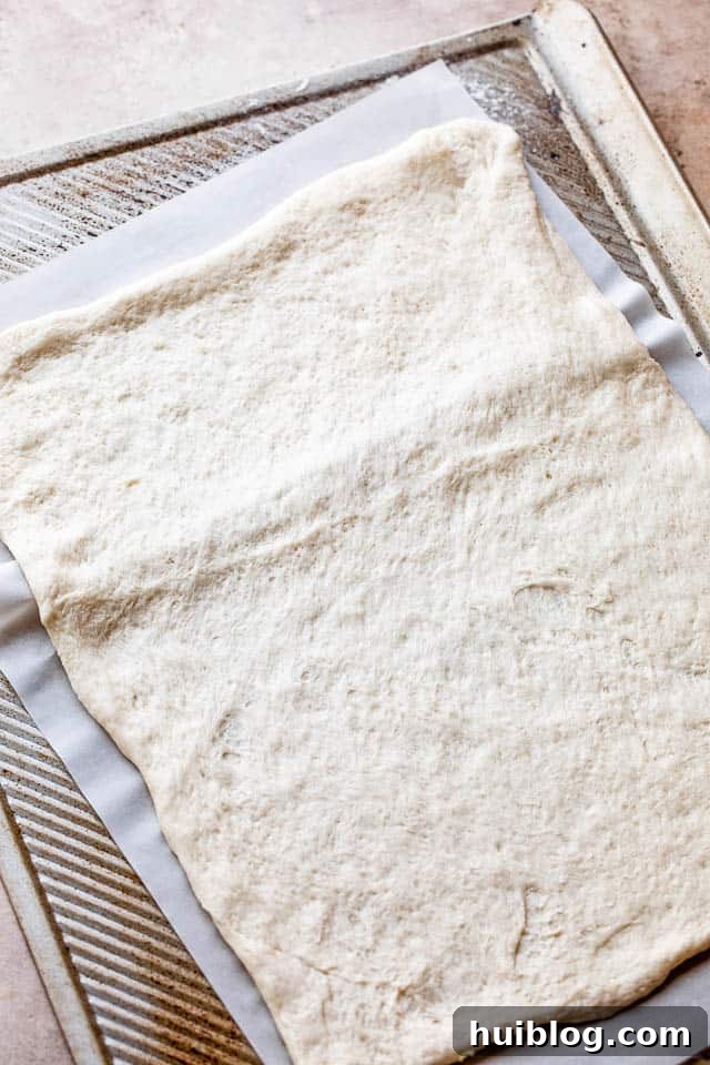 Smoky Capricciosa Pizza 4 raw pizza dough on a baking sheet