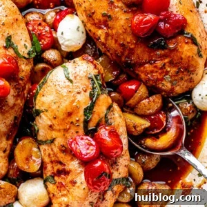 One-Pan Balsamic Chicken and Potatoes 7 Close-up overhead view of the finished baked balsamic chicken with potatoes, highlighting the golden chicken, vibrant tomatoes, and tender potatoes, ready to be served.