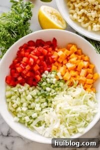 This macaroni salad is zesty, creamy, and full of great flavor and texture. Perfect for family gatherings or as a side to any weeknight meal! Bowl of macaroni salad ingredients laid out