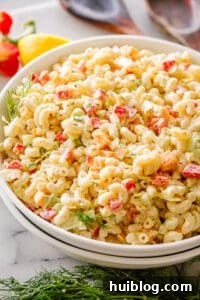 This macaroni salad is zesty, creamy, and full of great flavor and texture. Perfect for family gatherings or as a side to any weeknight meal! Macaroni salad in a large mixing bowl