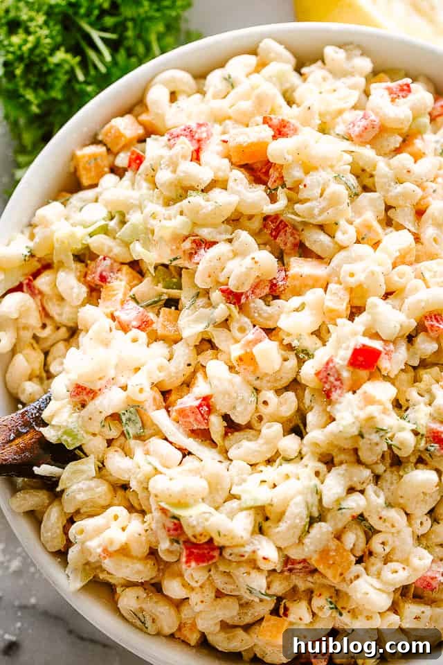 This macaroni salad is zesty, creamy, and full of great flavor and texture. Perfect for family gatherings or as a side to any weeknight meal! Large serving bowl of creamy macaroni salad